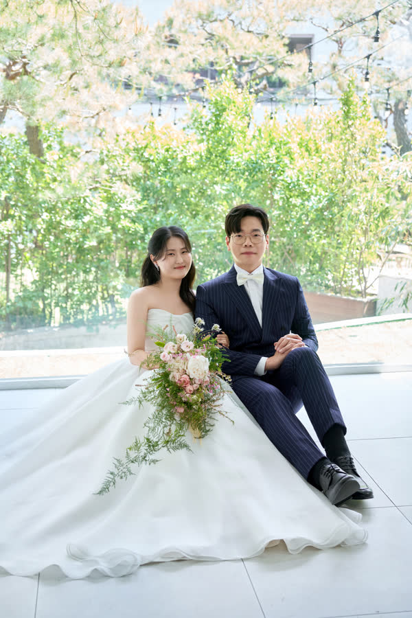 창가에 나란히 앉은 신랑 신부